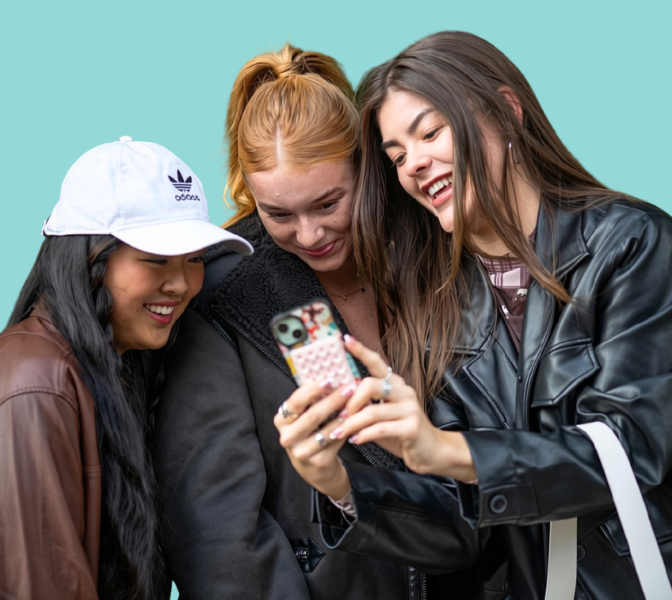 image of 3 young women smiling at a phone